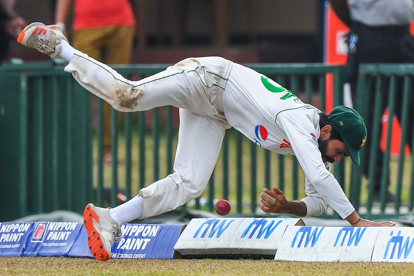 An acrobatic Fawad Alam attempts to stop a boundary